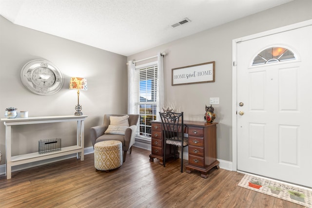 office space with visible vents, baseboards, and wood finished floors