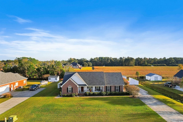 view of front of house featuring driveway, brick siding, and a front yard