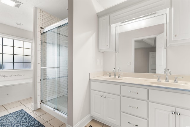 bathroom featuring tile patterned flooring, a shower stall, and a sink