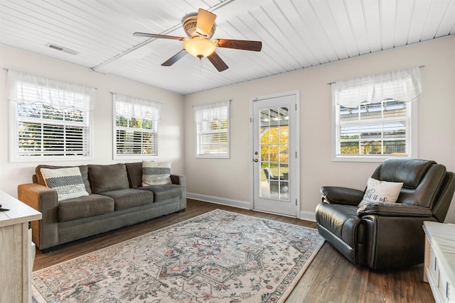 living area featuring a ceiling fan, baseboards, visible vents, and dark wood-style flooring