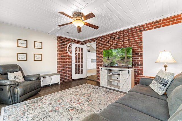 living room with visible vents, brick wall, wood finished floors, and a ceiling fan