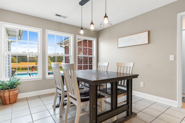 dining room featuring visible vents, a textured ceiling, baseboards, and light tile patterned flooring