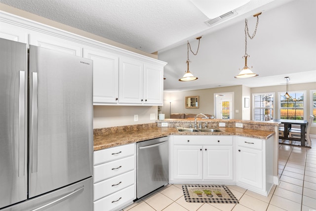 kitchen with stainless steel appliances, visible vents, white cabinetry, a sink, and a peninsula