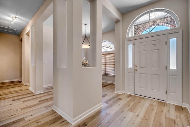 entryway featuring a textured ceiling and light hardwood / wood-style floors