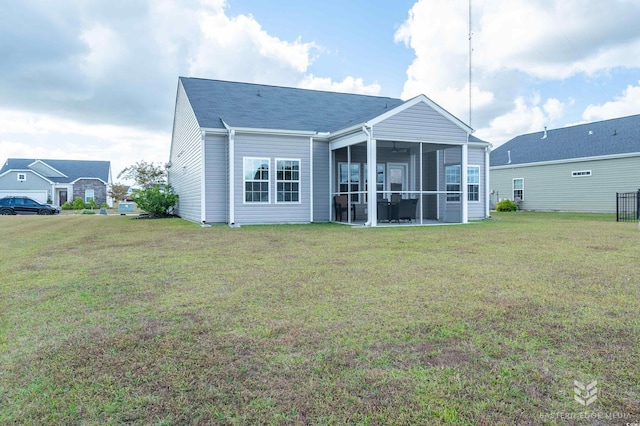 back of house with a lawn and a sunroom