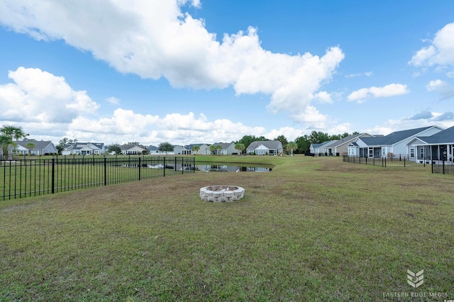 view of yard with a water view and an outdoor fire pit