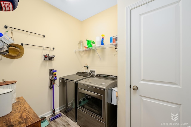 laundry area with washer and clothes dryer and light hardwood / wood-style flooring