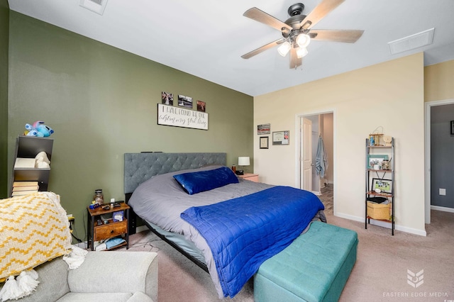 bedroom with light carpet, connected bathroom, and ceiling fan