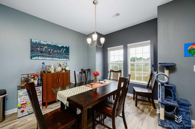 dining room with a chandelier and light wood-type flooring