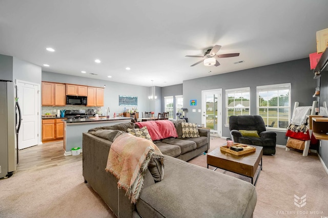 living room featuring ceiling fan and light hardwood / wood-style floors