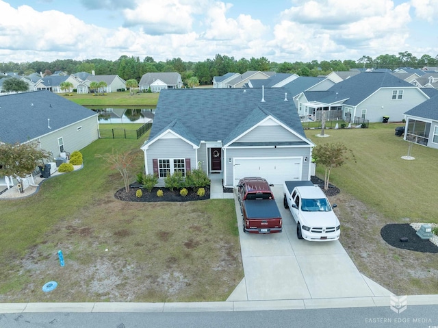 view of front of home featuring a water view, a front yard, and a garage