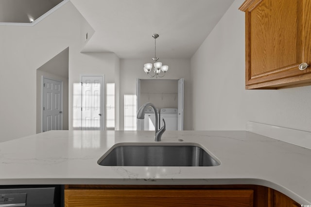 kitchen with a chandelier, light stone countertops, dishwasher, and sink