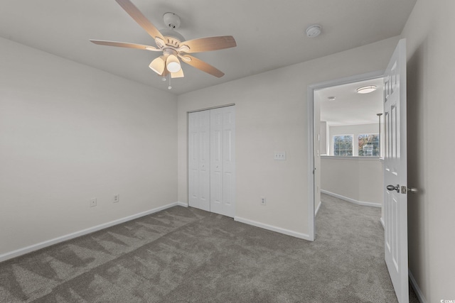 unfurnished bedroom with ceiling fan, a closet, and carpet