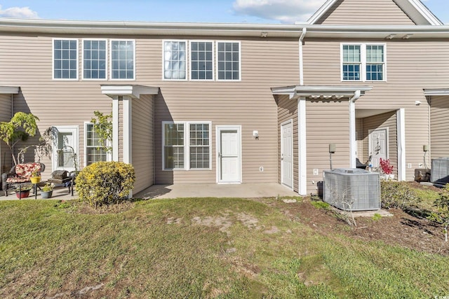 rear view of property with a yard, a patio, and cooling unit