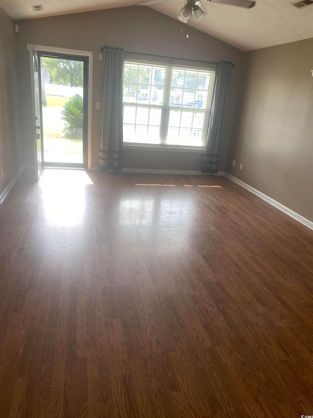 spare room featuring dark hardwood / wood-style floors, vaulted ceiling, plenty of natural light, and ceiling fan