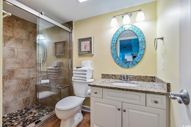 bathroom featuring tile patterned flooring, vanity, toilet, and an enclosed shower