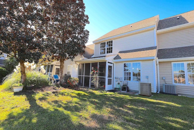 back of house with a sunroom, central AC unit, and a lawn