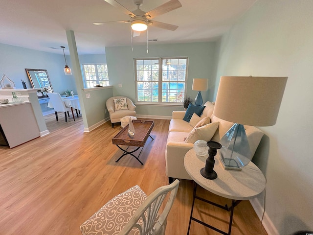 living room featuring ceiling fan and light hardwood / wood-style flooring