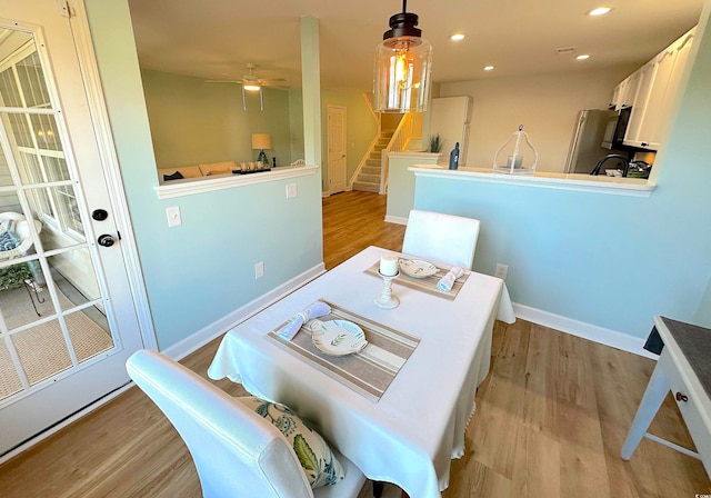 dining area with ceiling fan and light hardwood / wood-style flooring