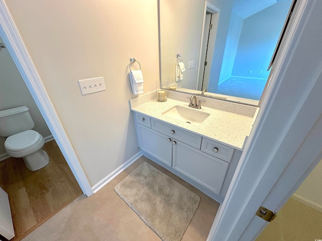 bathroom featuring vanity, toilet, and wood-type flooring