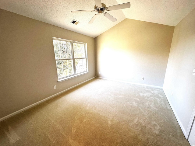 empty room featuring carpet, ceiling fan, lofted ceiling, and a textured ceiling