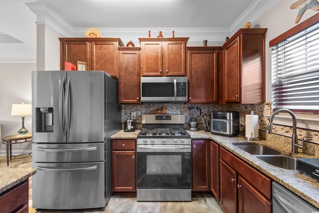 kitchen featuring appliances with stainless steel finishes, light wood-type flooring, light stone counters, ornamental molding, and sink