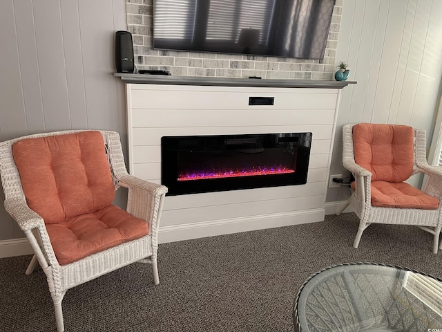 living area featuring carpet flooring, baseboards, and a glass covered fireplace