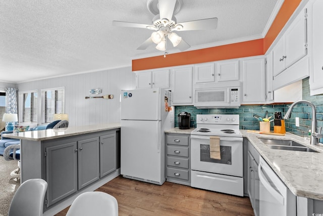 kitchen featuring white appliances, a textured ceiling, a sink, and gray cabinets