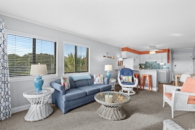carpeted living room featuring crown molding and ceiling fan