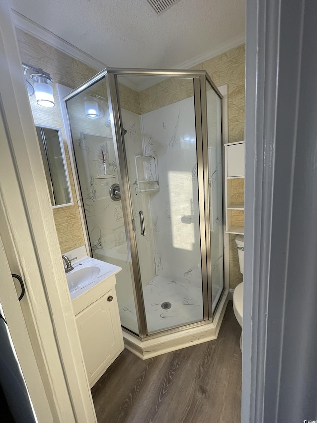 bathroom featuring vanity, a marble finish shower, wood finished floors, and toilet