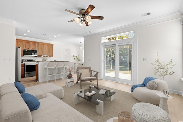 living room featuring crown molding, ceiling fan, and light wood-type flooring