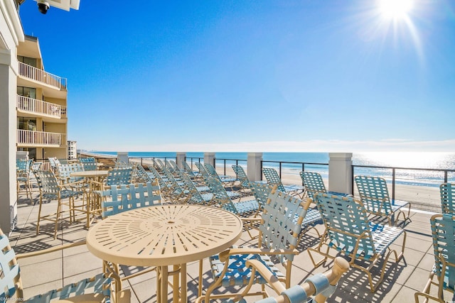 balcony with a water view and a view of the beach