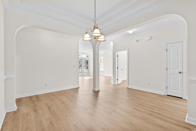 spare room featuring ornamental molding, a chandelier, and light wood-type flooring