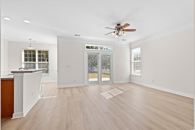 unfurnished living room featuring ceiling fan, ornamental molding, and light hardwood / wood-style floors