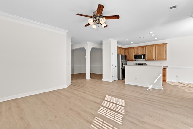 kitchen with light hardwood / wood-style flooring, ceiling fan, stainless steel appliances, ornamental molding, and a kitchen island