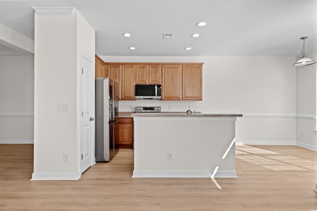 kitchen featuring decorative light fixtures, light wood-type flooring, and appliances with stainless steel finishes