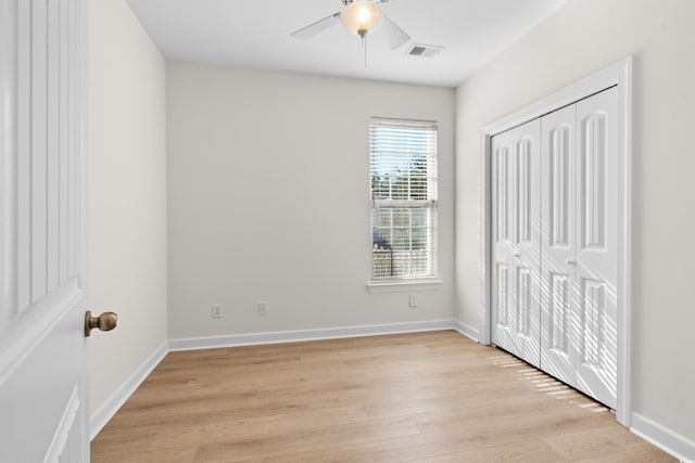 unfurnished bedroom with ceiling fan, a closet, and light wood-type flooring