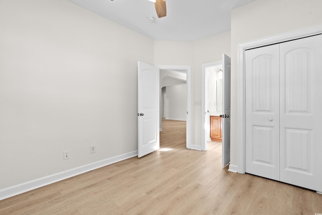 unfurnished bedroom featuring ceiling fan, light wood-type flooring, and a closet