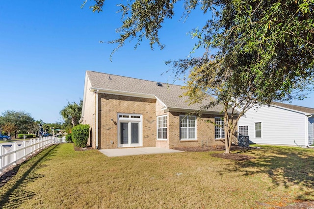 back of property with a lawn and a patio area