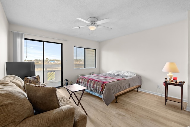 bedroom featuring a textured ceiling, light wood-type flooring, and ceiling fan