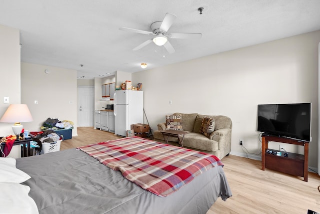 bedroom featuring ceiling fan, white refrigerator, and light hardwood / wood-style floors