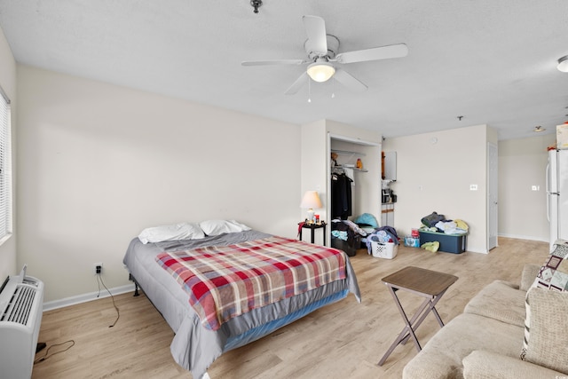 bedroom with light hardwood / wood-style floors, a closet, and ceiling fan