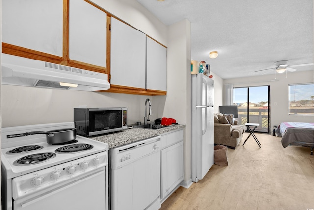 kitchen with white appliances, white cabinets, sink, light hardwood / wood-style flooring, and a textured ceiling