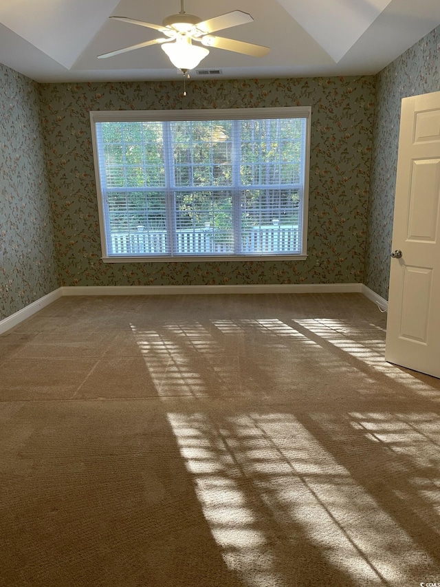 empty room with ceiling fan, plenty of natural light, and carpet