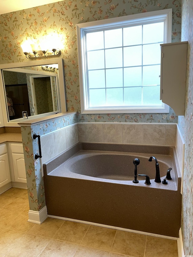 bathroom featuring a bath, vanity, tile patterned floors, and a wealth of natural light