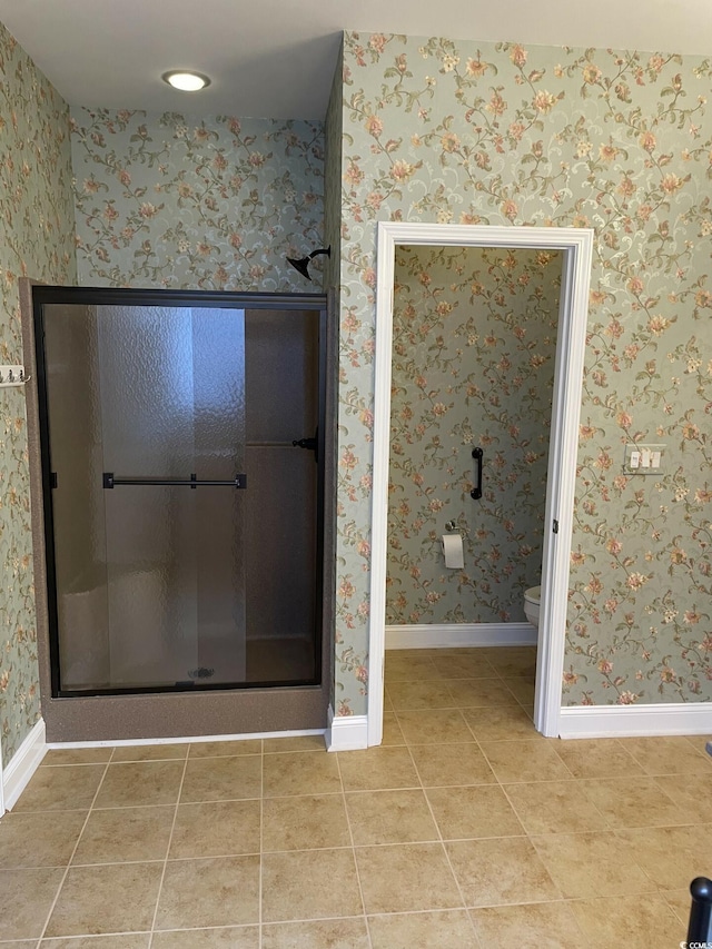 bathroom featuring tile patterned flooring, toilet, and an enclosed shower