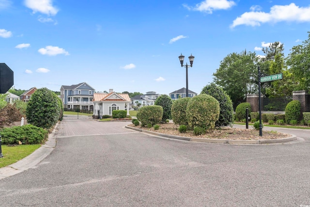 338 Harbour View Dr, Myrtle Beach, SC 29579 - view of asphalt road featuring curbs, street lighting, and a gate