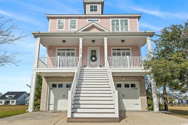 338 Harbour View Dr, Myrtle Beach, SC 29579 - raised beach house with driveway, a porch, stairs, and an attached garage