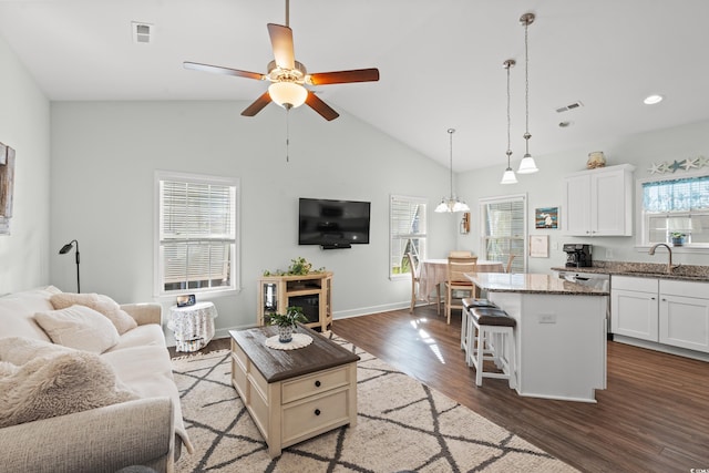 living room featuring hardwood / wood-style floors, plenty of natural light, sink, and ceiling fan with notable chandelier