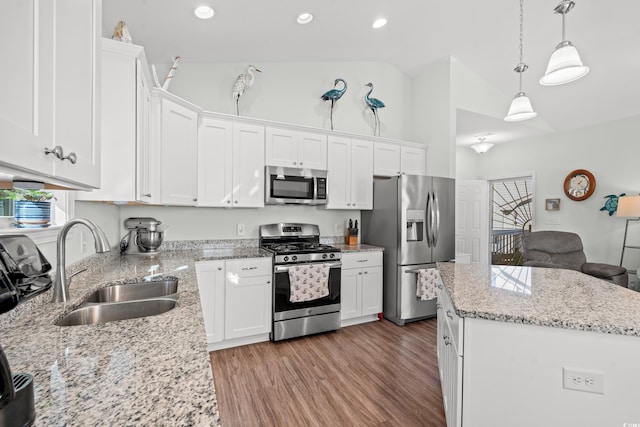 kitchen featuring white cabinetry, sink, stainless steel appliances, and vaulted ceiling